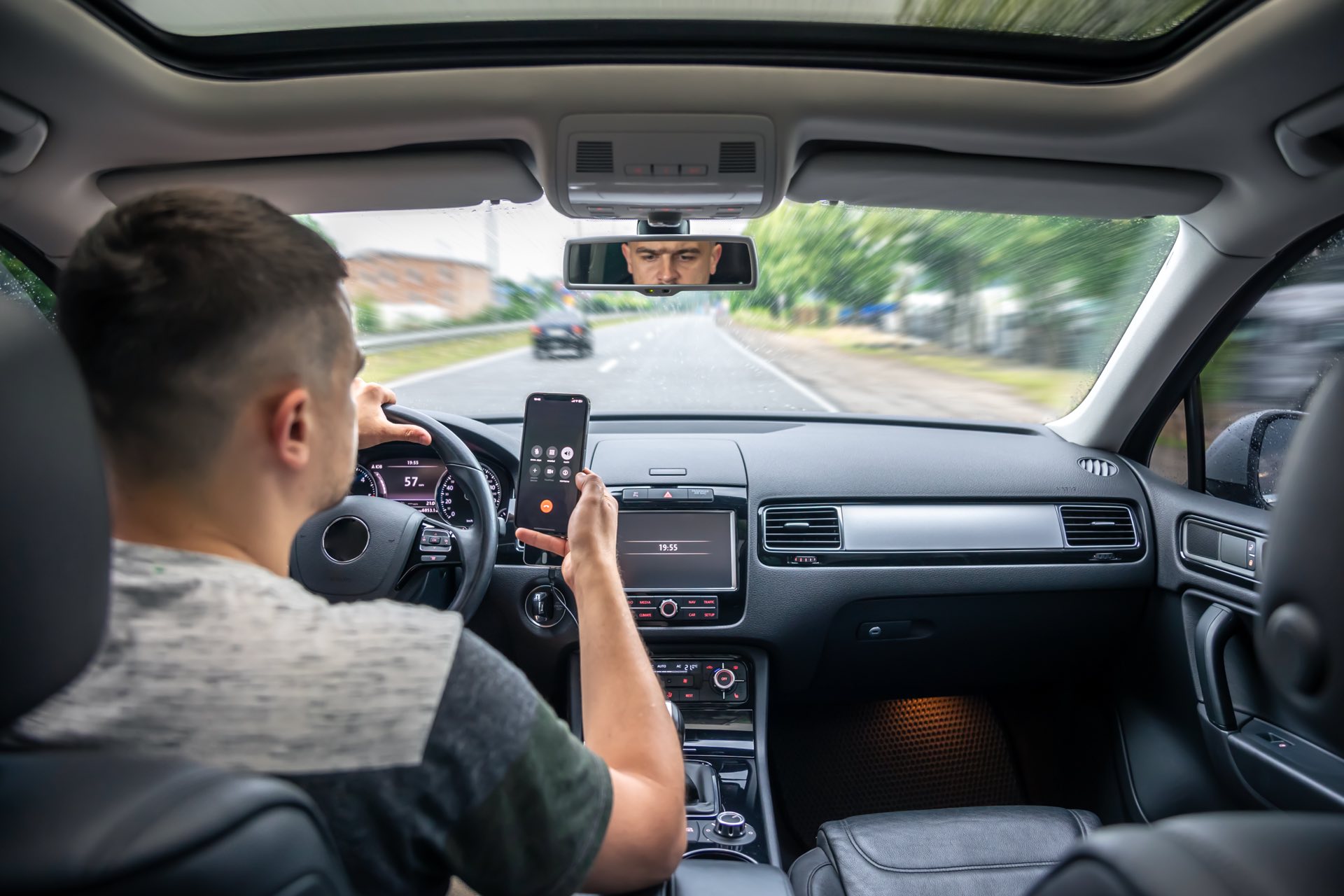 Person driving in a car on his phone