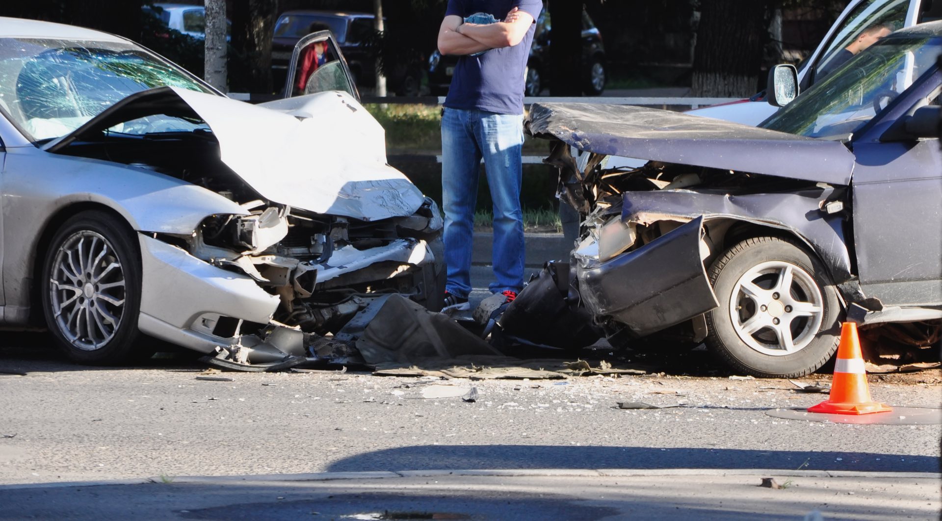 Two cars involved in a car accident with a person standing in between both cars