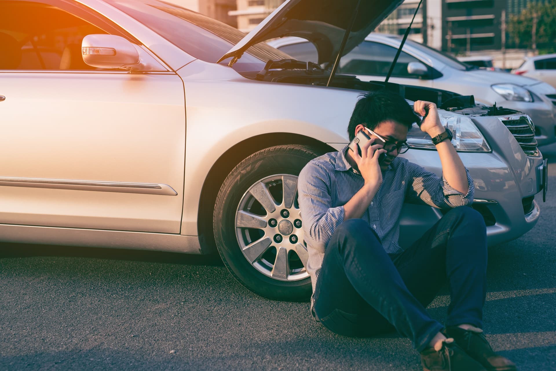 Young asian handsome man siting by the Broken Down car