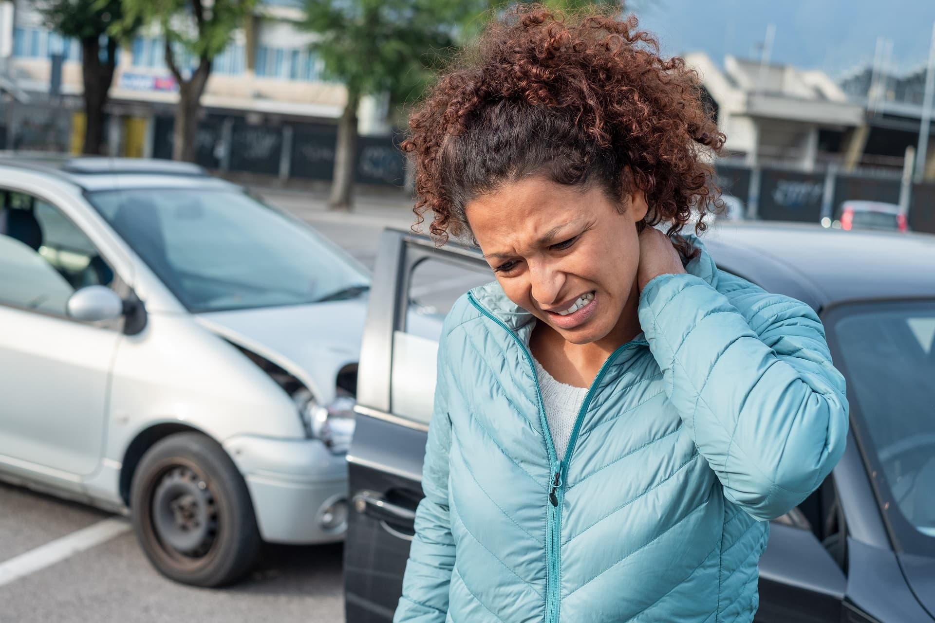 Woman suffering whiplash after bad cars pile up