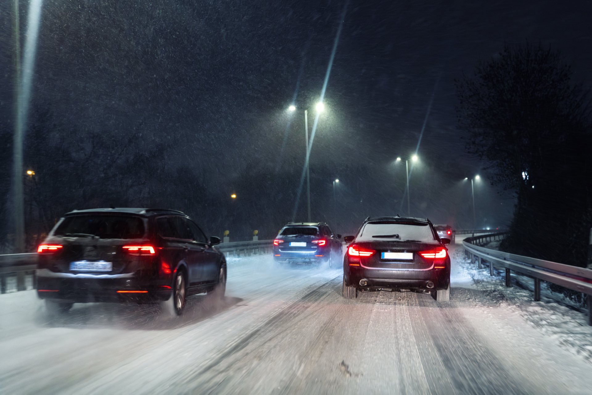 Three cars driving on a snowy highway