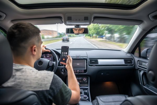 Person driving in a car on his phone