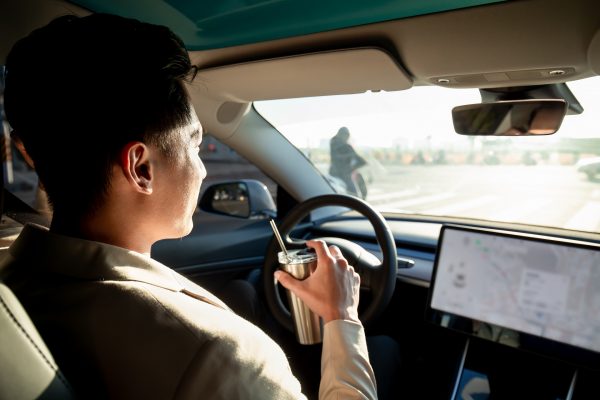 Driver in automated car near cyclist | auto accident lawyer | Henderson Taylor Law Firm
